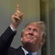 Former President Donald Trump stares up at the sun while pointing at it.